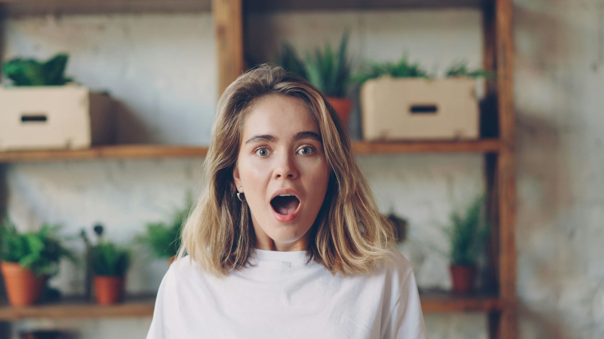 Young woman with surprised expression looking forward.
