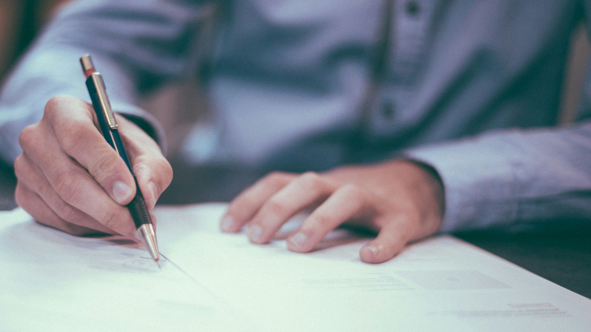 man writing on paper