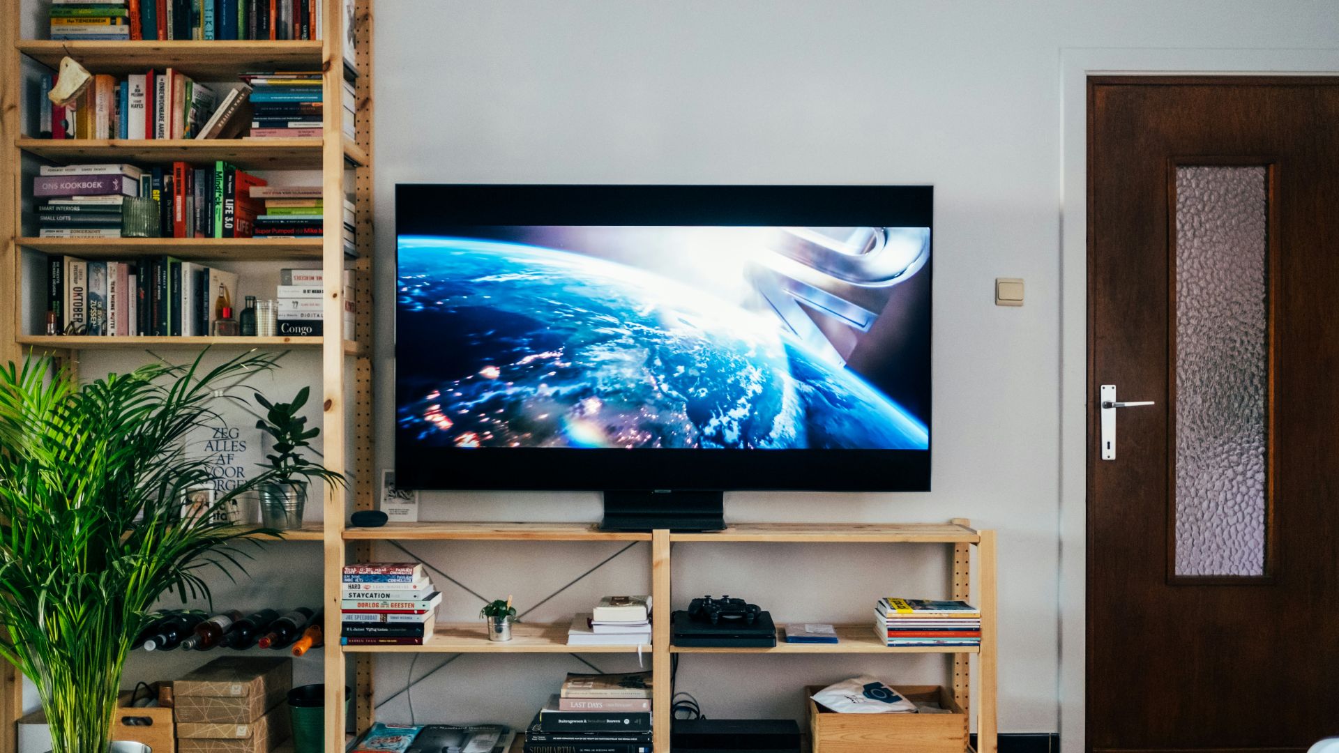 black flat screen tv turned on near brown wooden shelf