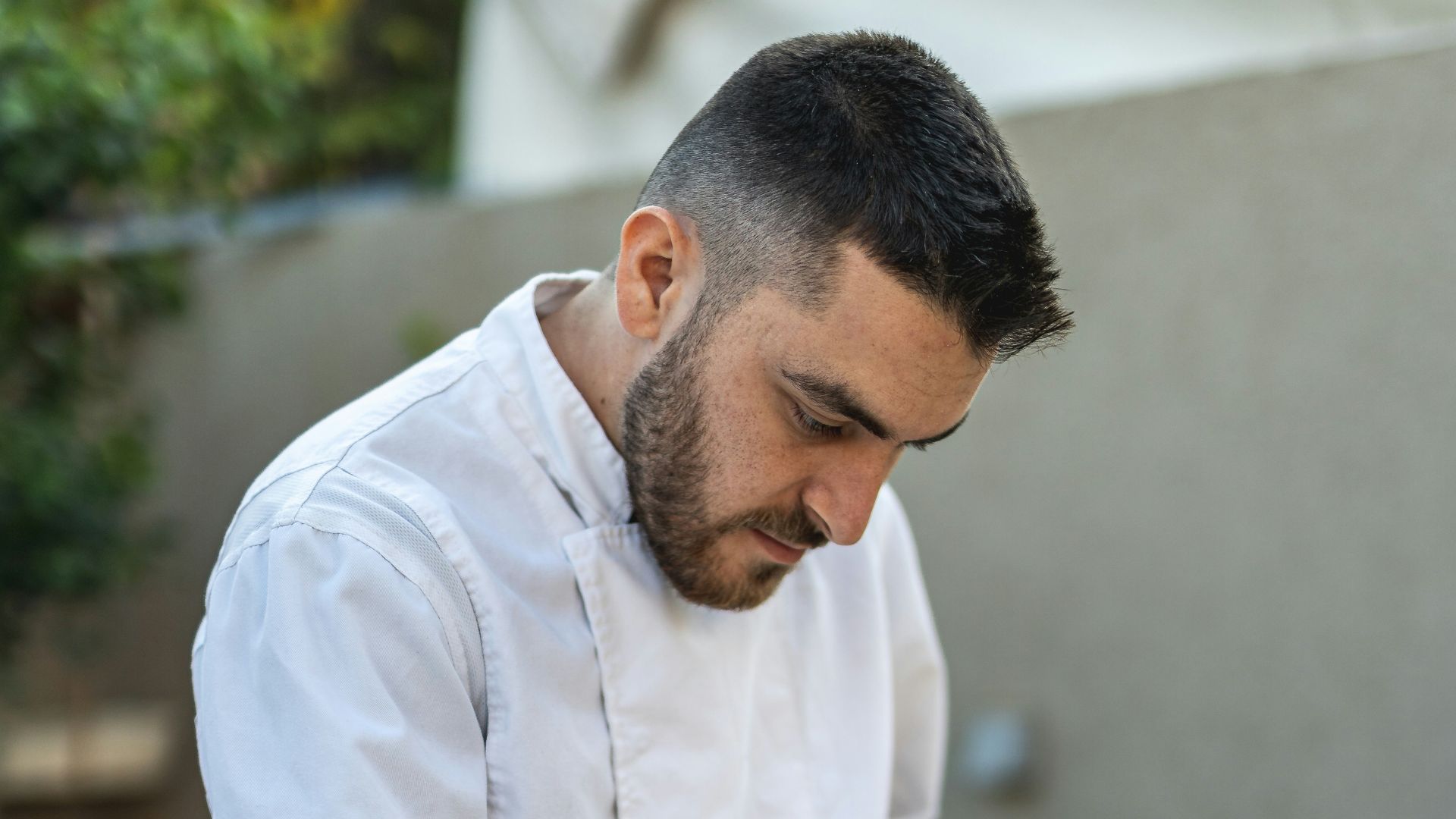 a man in a chef's uniform preparing food on a table