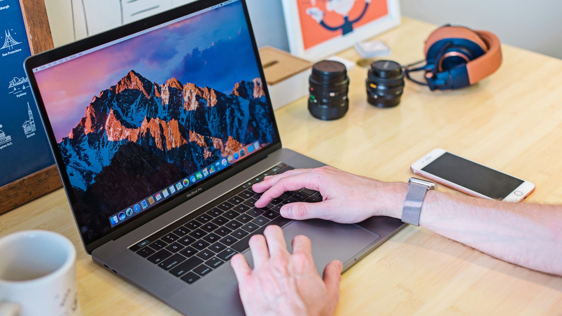 MacBook Pro turned on beside white ceramic mug