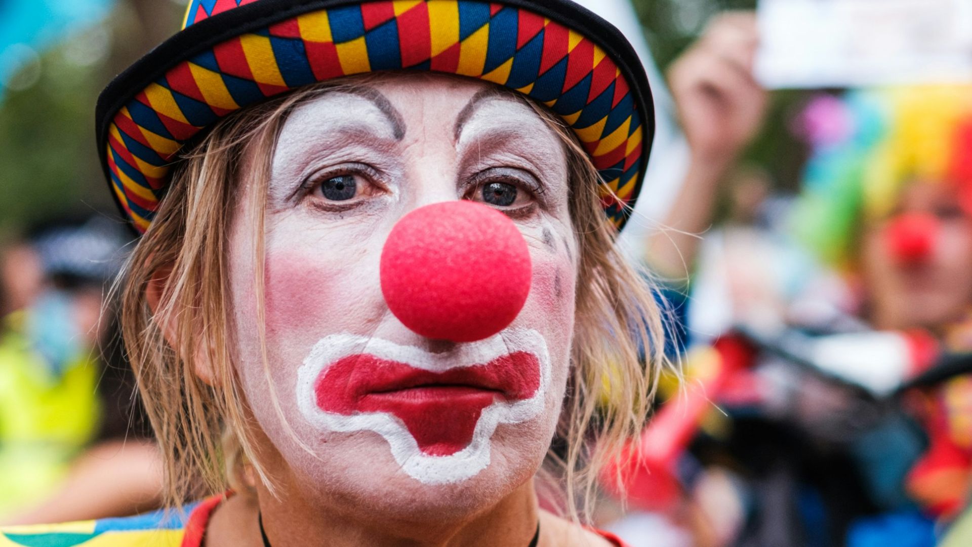 woman in yellow and red stripe shirt with white and red candy on face