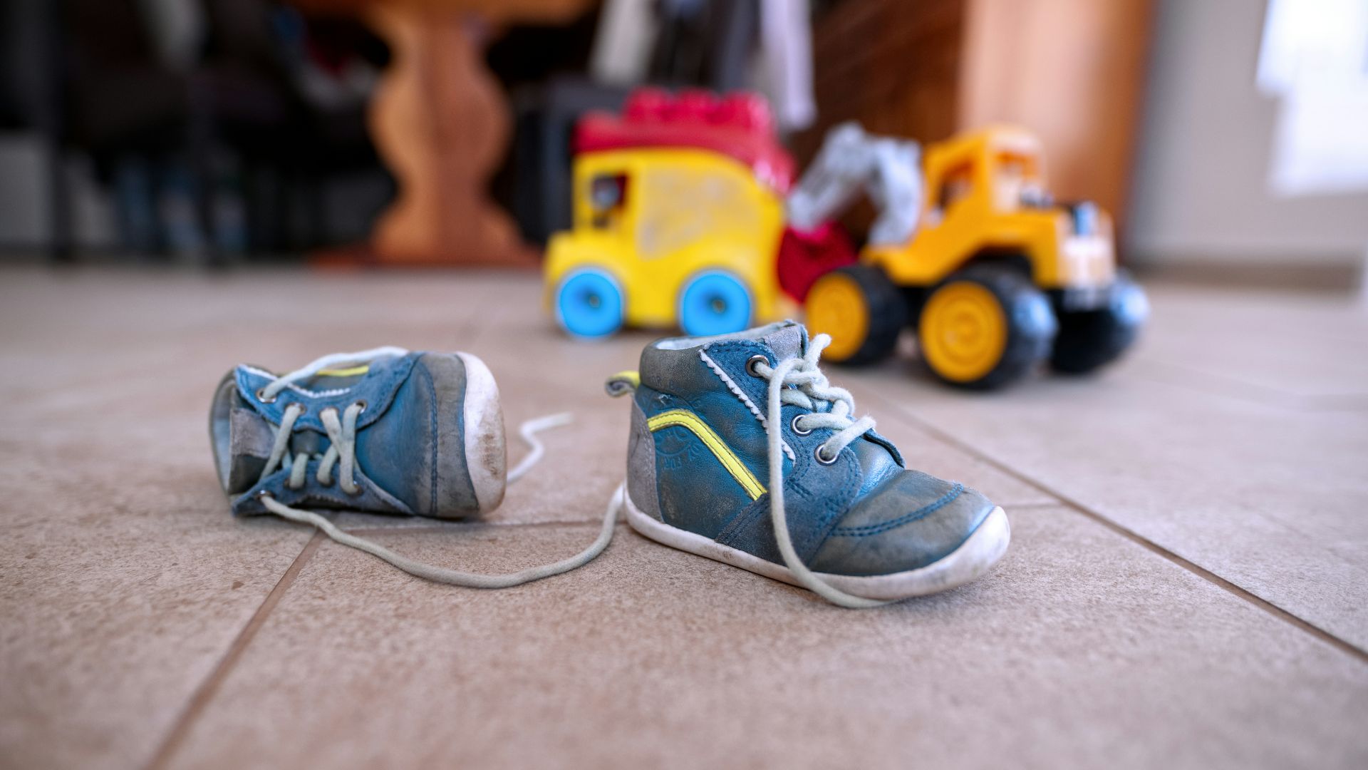 pair of blue sneakers near yellow plastic toys