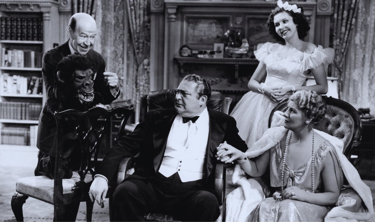 Gettyimages -143926406, Lionel Barrymore And Ann Miller In 'You Can't Take It With You' Lionel Barrymore watching man show off ape mask with Ann Miller behind him in a scene from the film 'You Can't Take It With You', 1938.