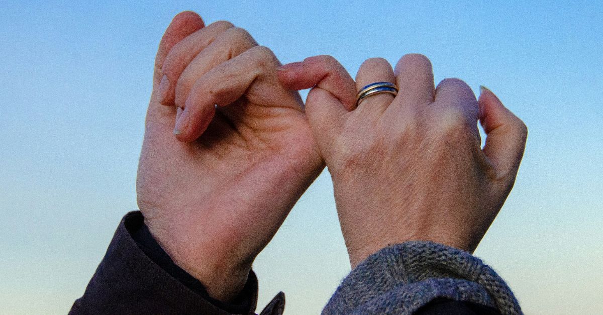 person in gray sweater with silver ring