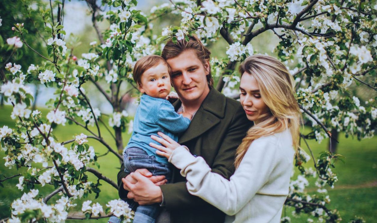 A Family Posing by a Flowering Tree in a Park