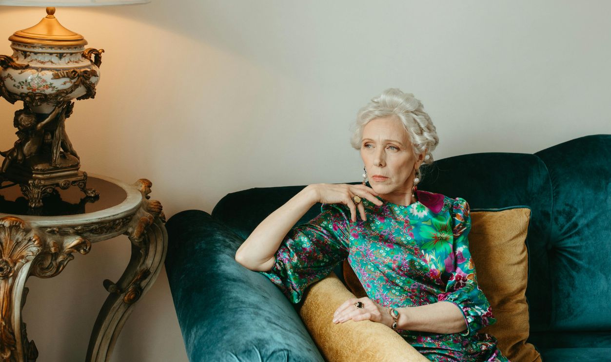 A Woman in Blue and Green Floral Dress Sitting on Sofa