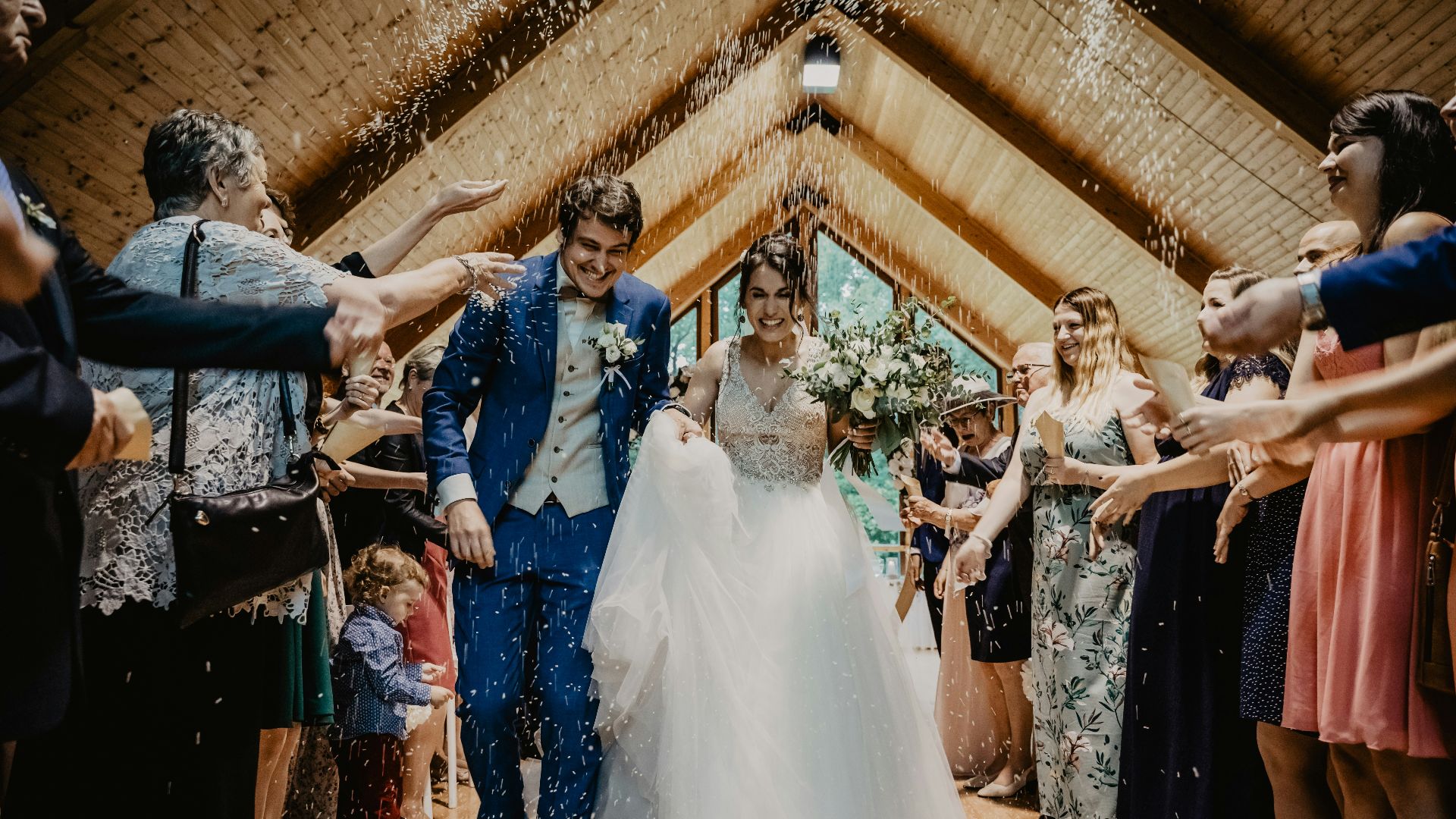 bride and groom standing beside brown wooden wall