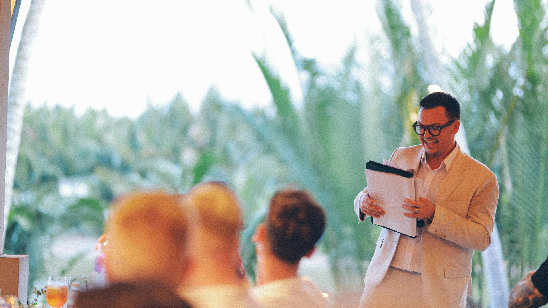 Man in suit presenting with a clipboard.