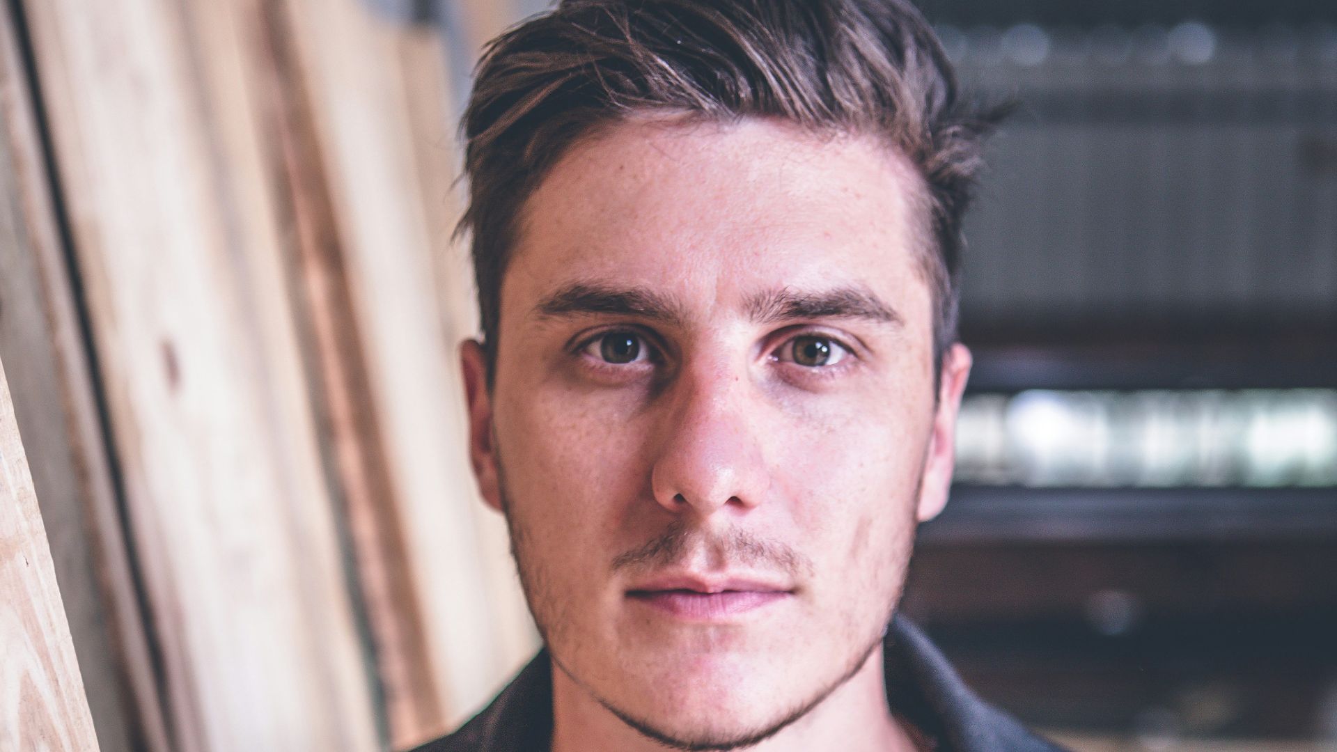 man standing beside wood planks