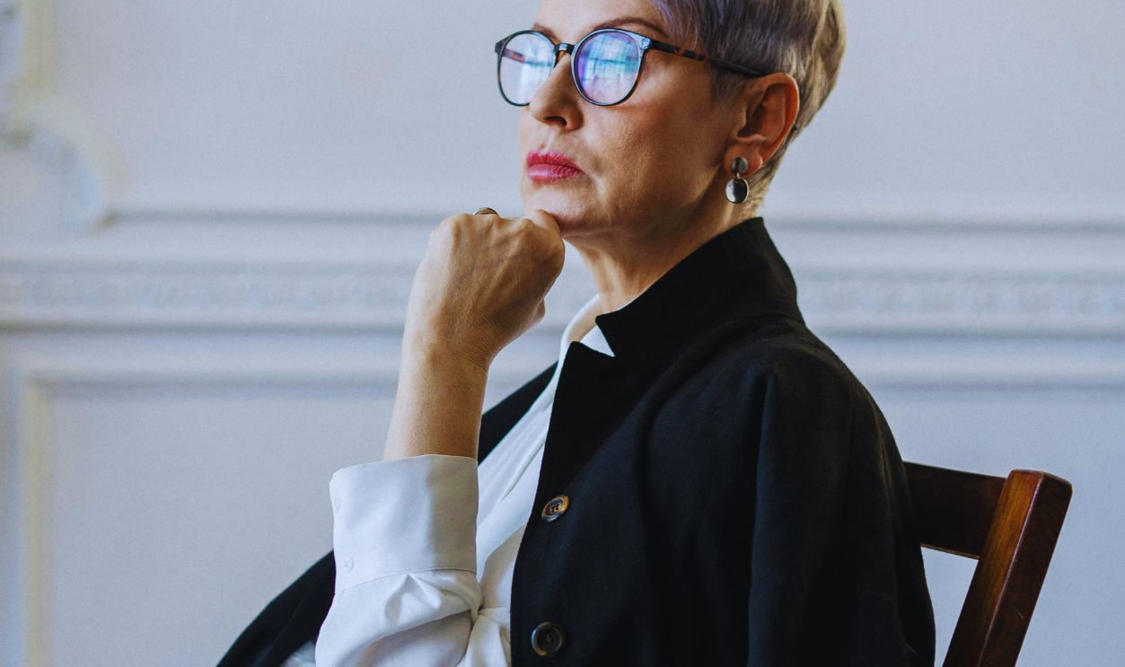 Woman in Black Coat Sitting on Brown Wooden Chair