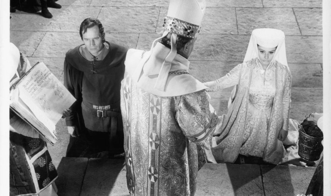 Charles Heston and Sofia Loren kneel during wedding ceremony in a scene from the film 'El Cid', 1961.