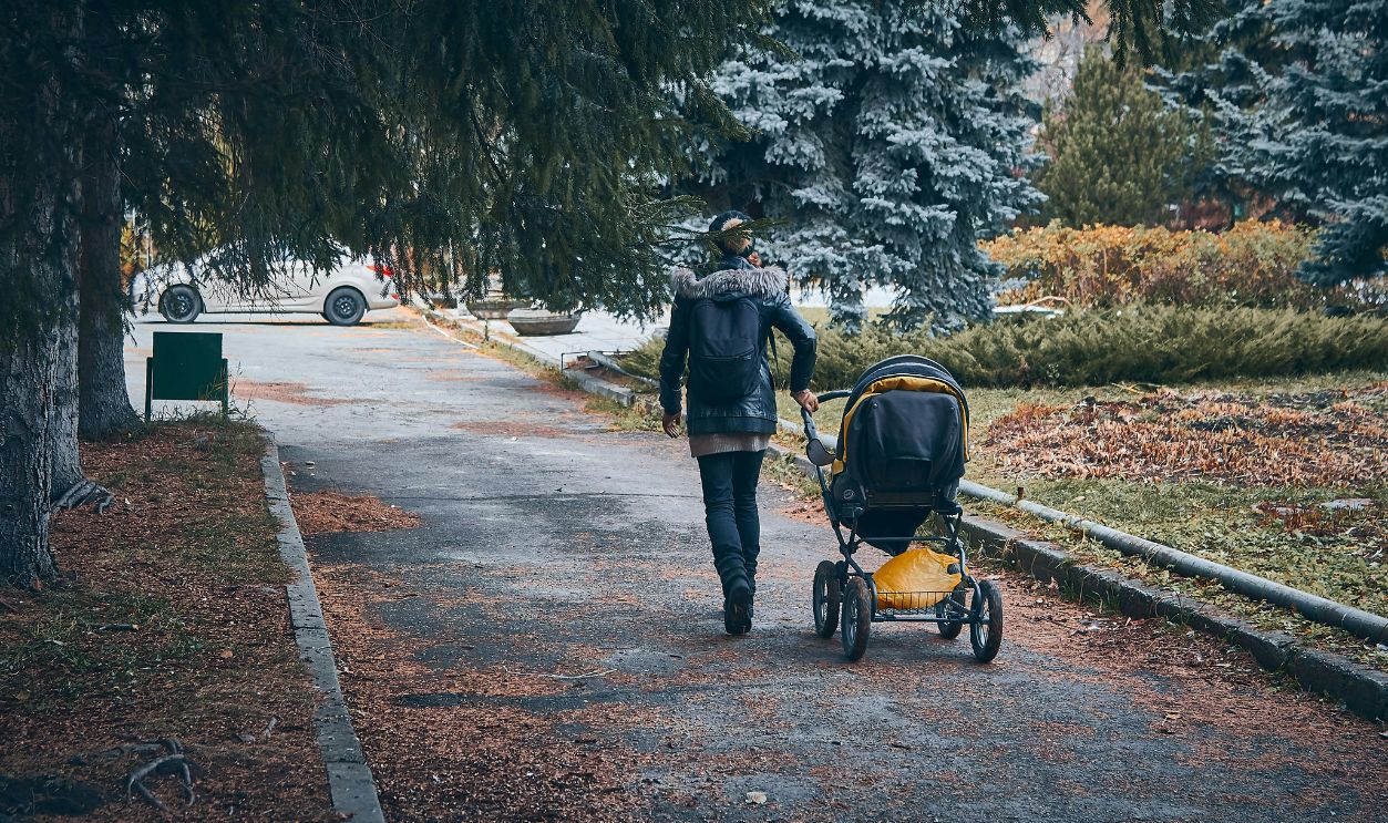 A Person Walking and Holding a Baby Stroller