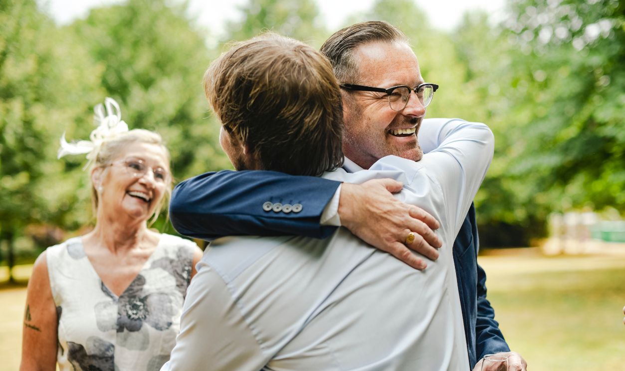 Fathers of the bride and groom hugging it out