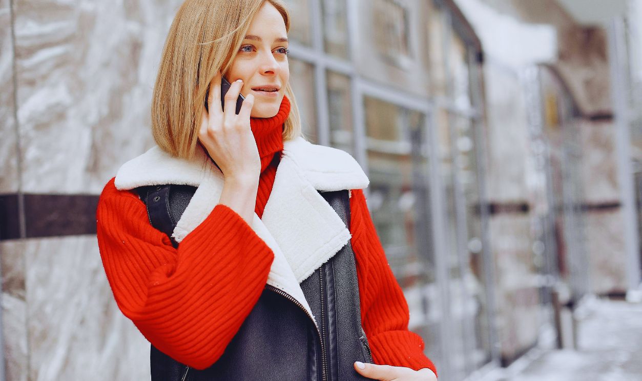 Woman in Red Turtle Neck Shirt Talking on the Phone