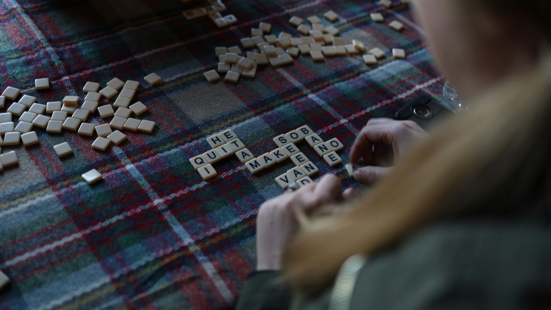 a woman playing a game of scrabble on the floor