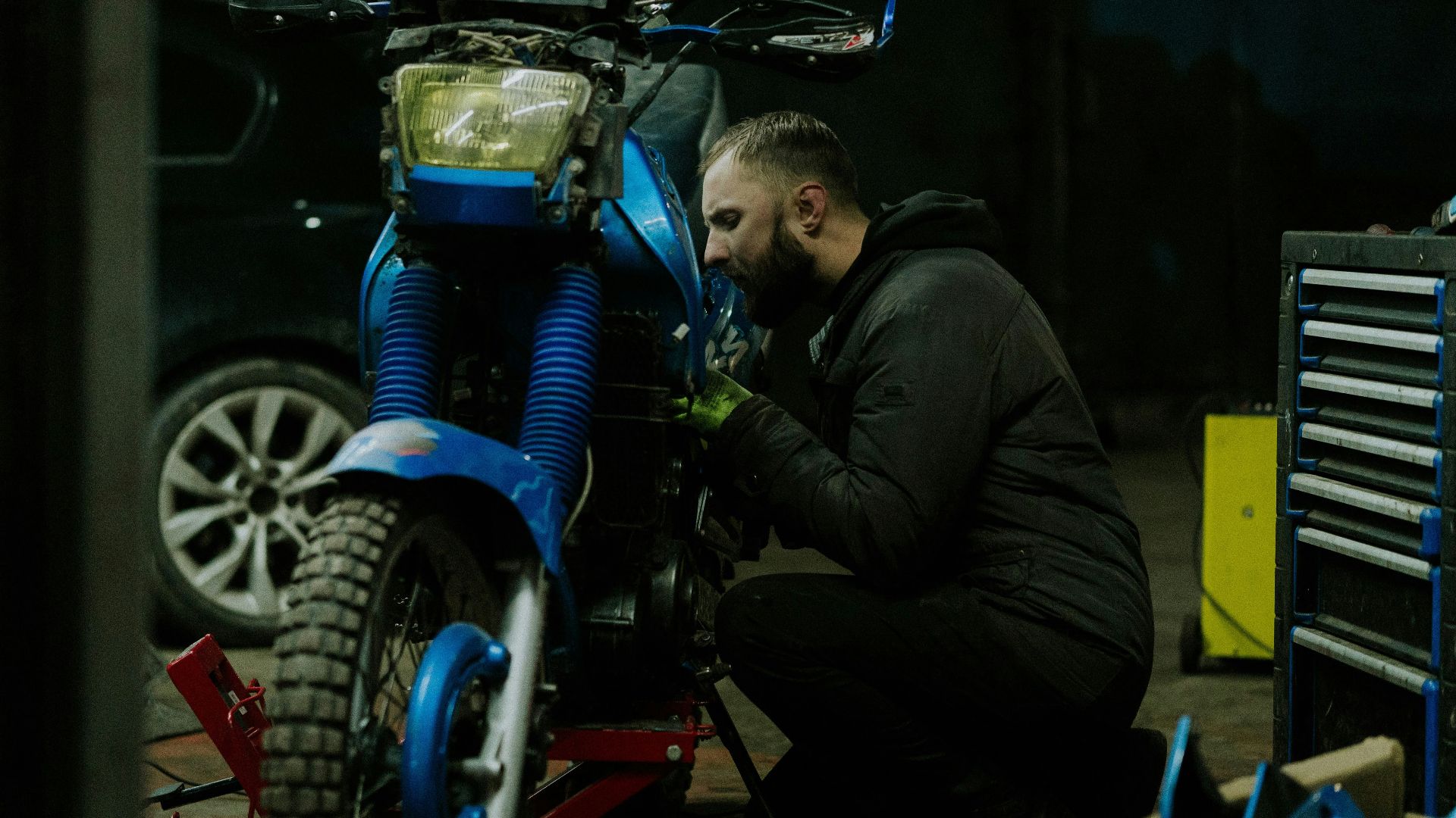 a man working on a motorcycle in a garage
