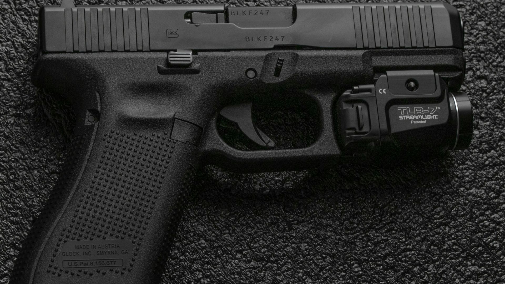 black semi automatic pistol on gray textile