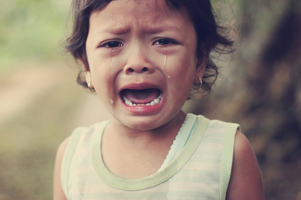 selective focus photography of girl crying