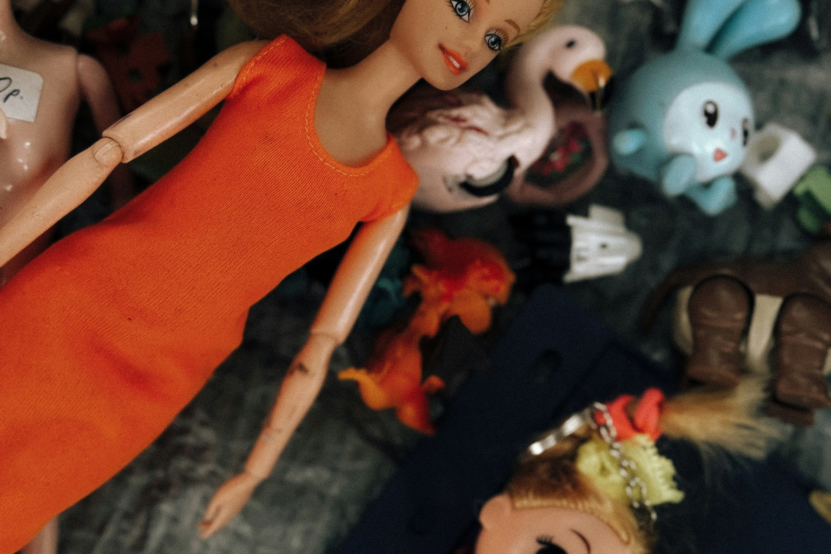 Several dolls and small toys scattered on a surface.