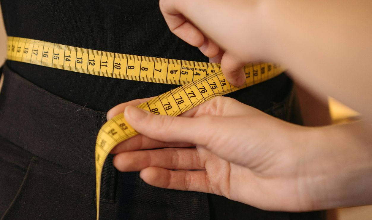 A Person Measuring a Woman's Waist