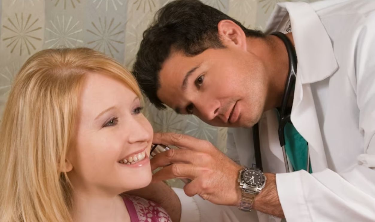 a man helping a woman get ready for a wedding