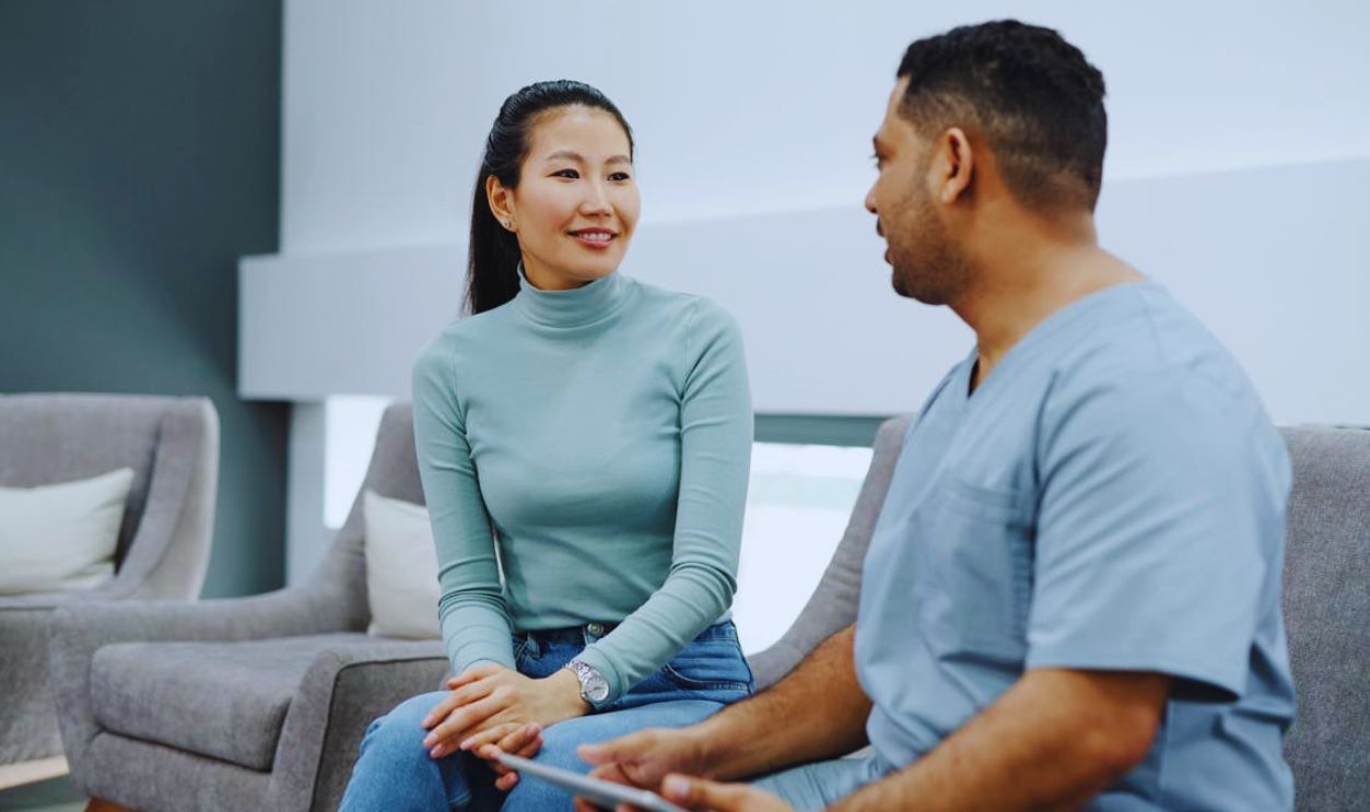 A Doctor Talking to a Patient while Holding a Tablet