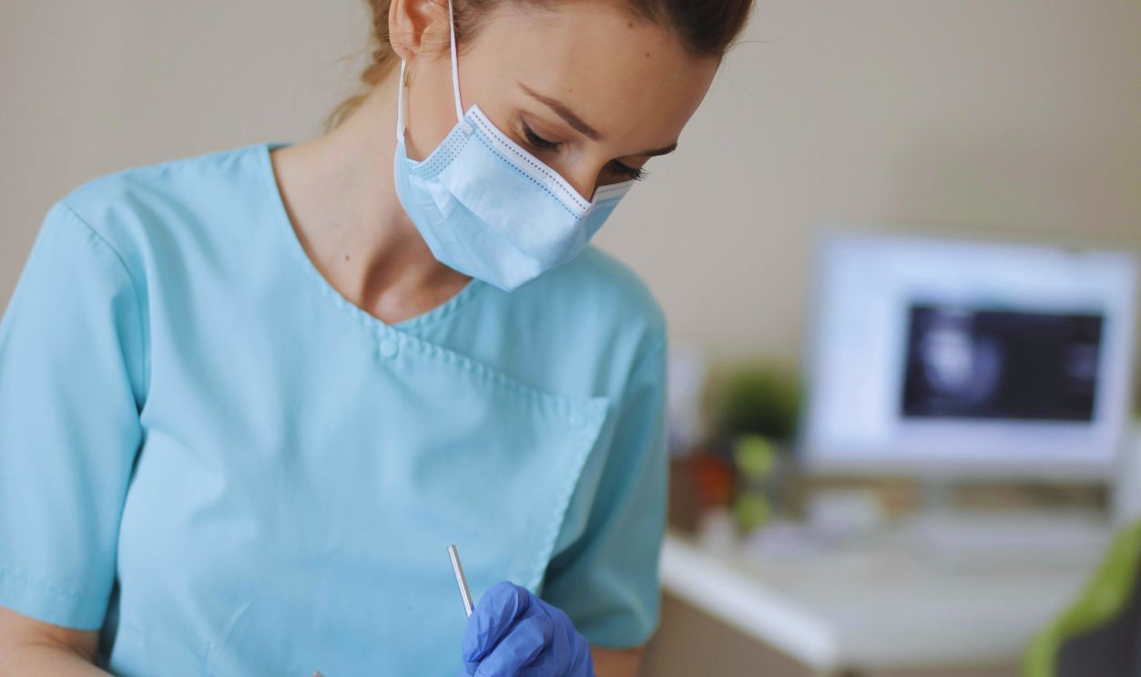 Young female dentist treating teeth of patient in modern clinic