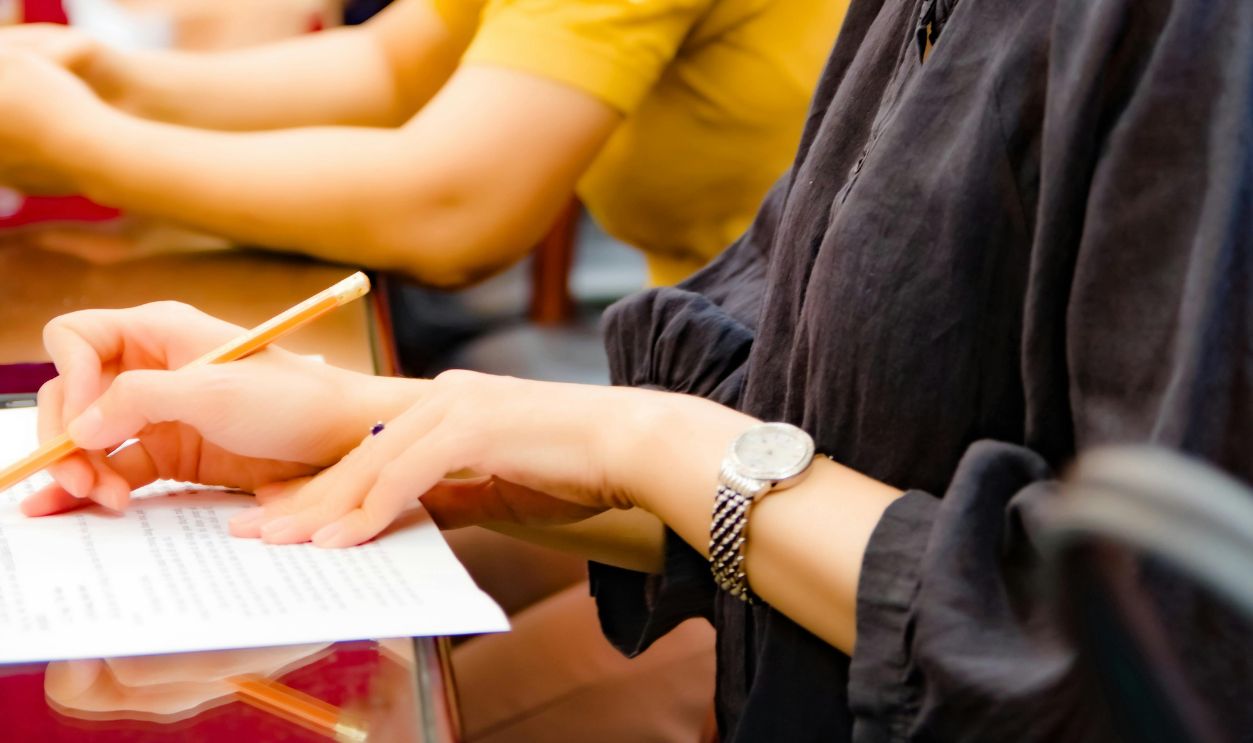 Side View of Woman in Black Long Sleeves Holding a Pen