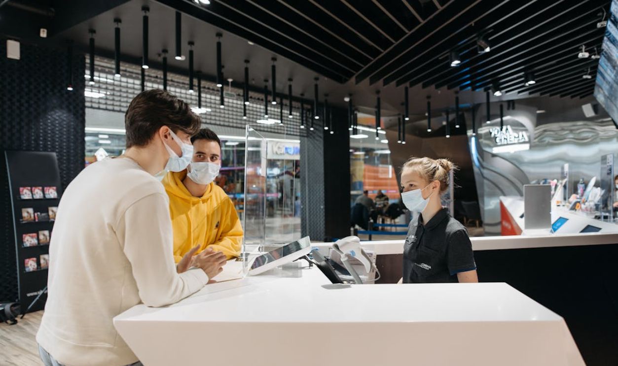 People Wearing Masks Standing at a Counter