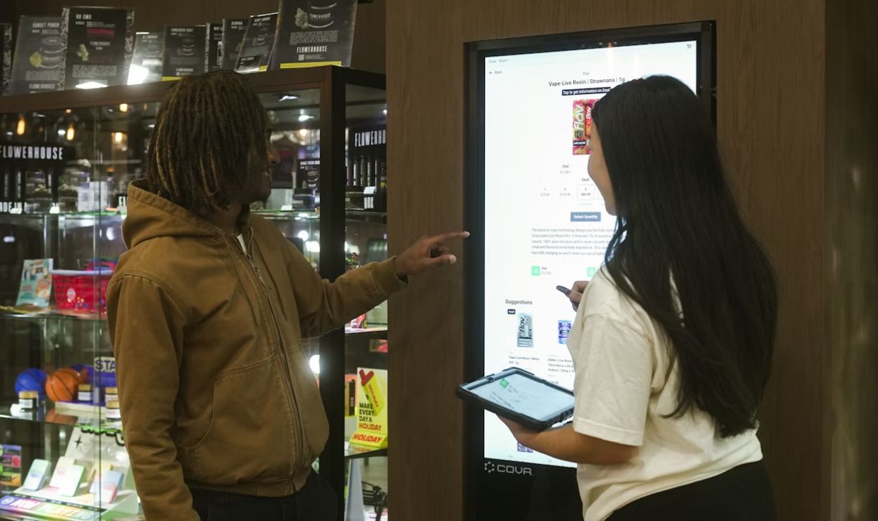 Two people interact with a digital display screen