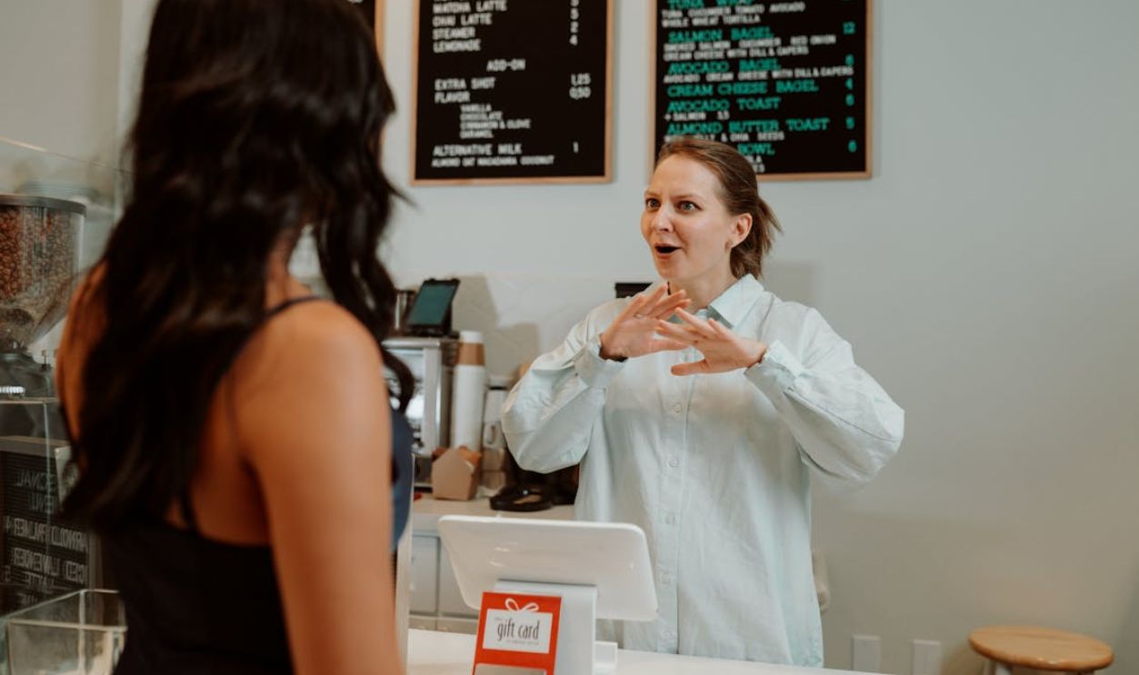 Cashier behind a Counter in front of a Customer
