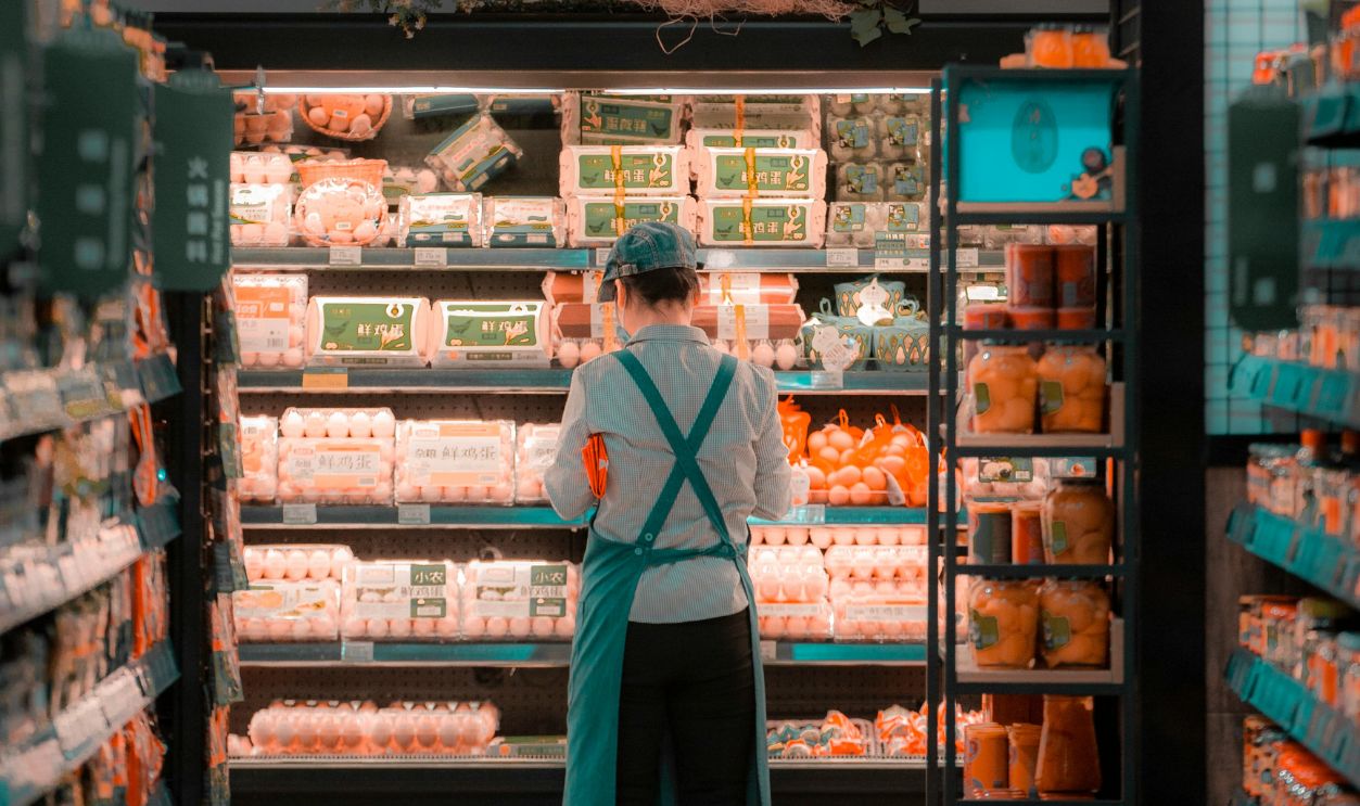 A Woman Employee of A Supermarket Standing Beside Chilled Products