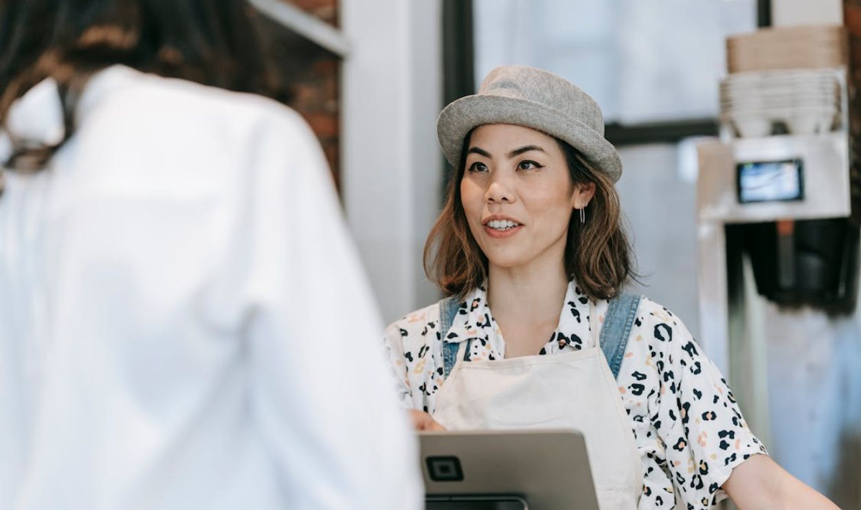 A Woman at a Counter Talking to a Customer
