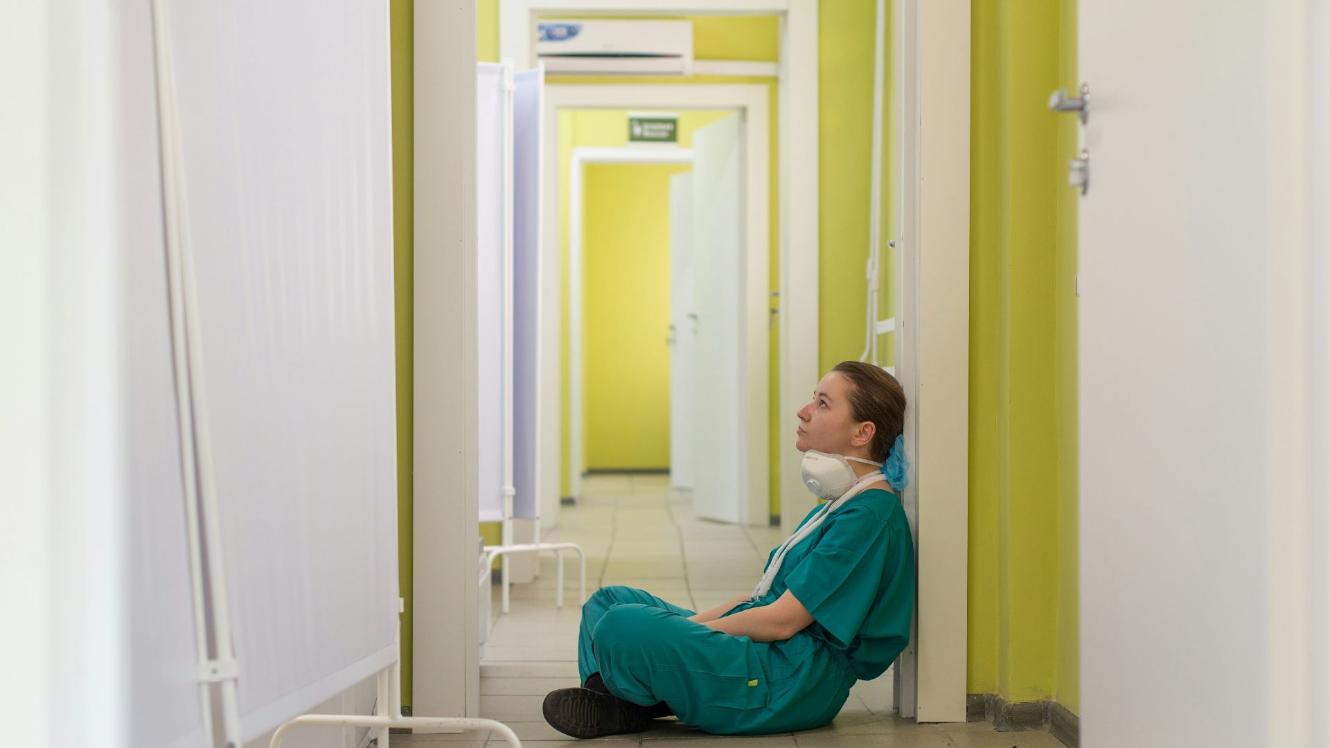 child in blue hoodie sitting on floor