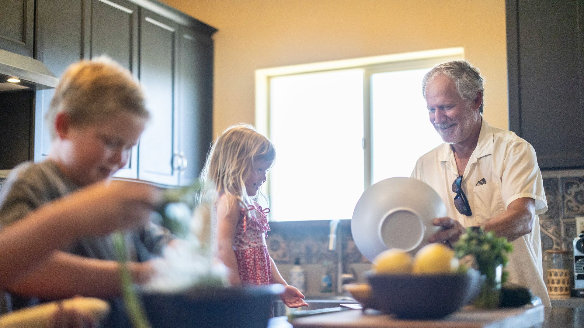 Grandfather and grandchildren prepare food in kitchen