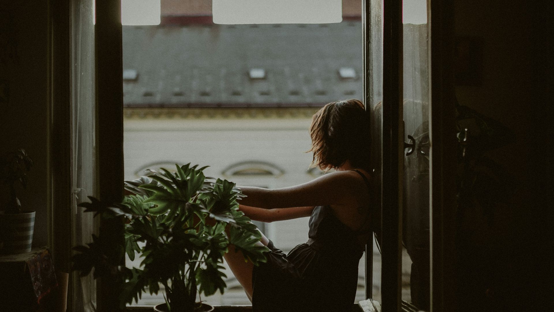 woman leaning on door looking outside