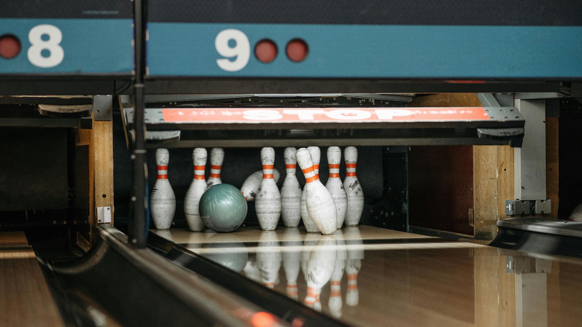 A bowling ball ready to knock down pins at a lively bowling alley.