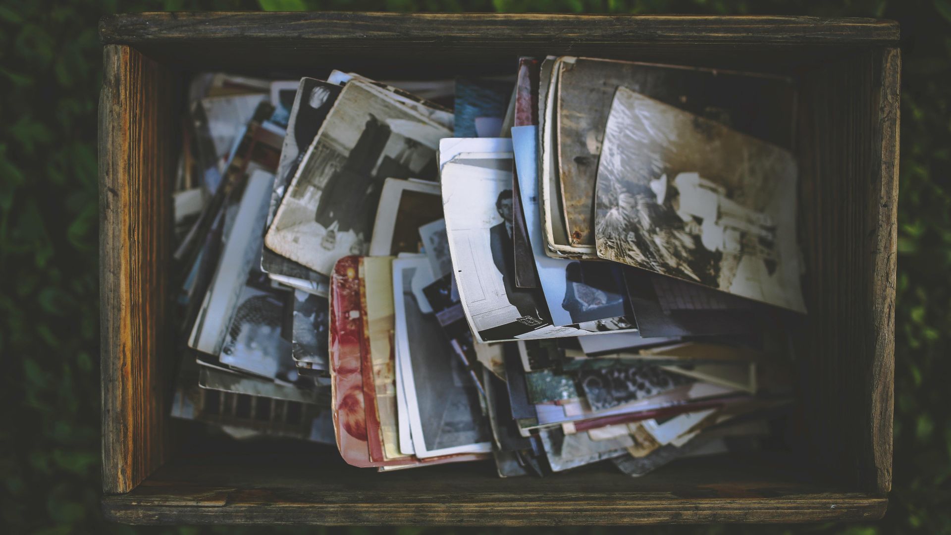A nostalgic collection of vintage photos in an old wooden box.