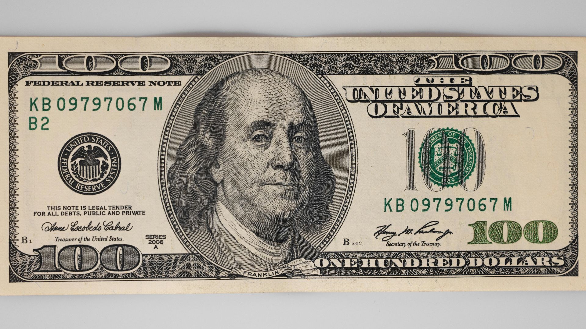 A detailed close-up of a US $100 bill featuring Benjamin Franklin on a white background.