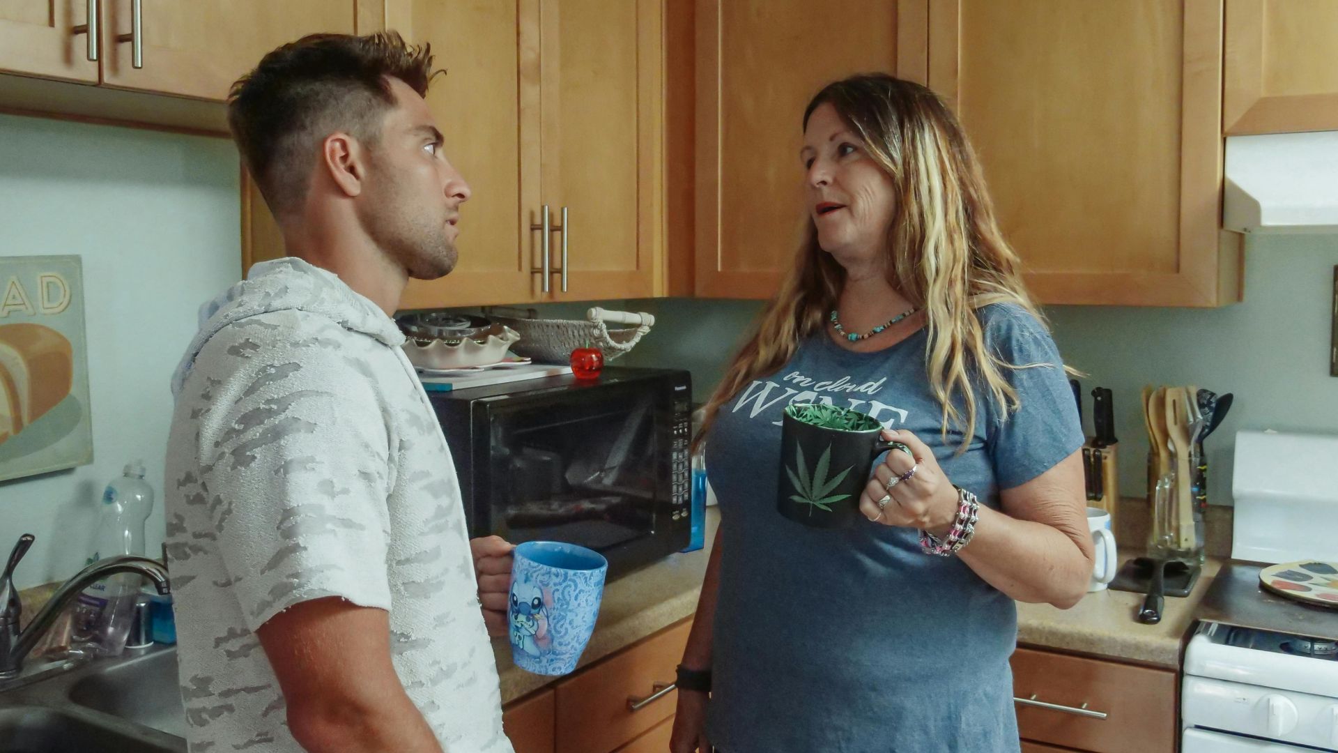 Mother and son enjoying a casual conversation in the kitchen over coffee.