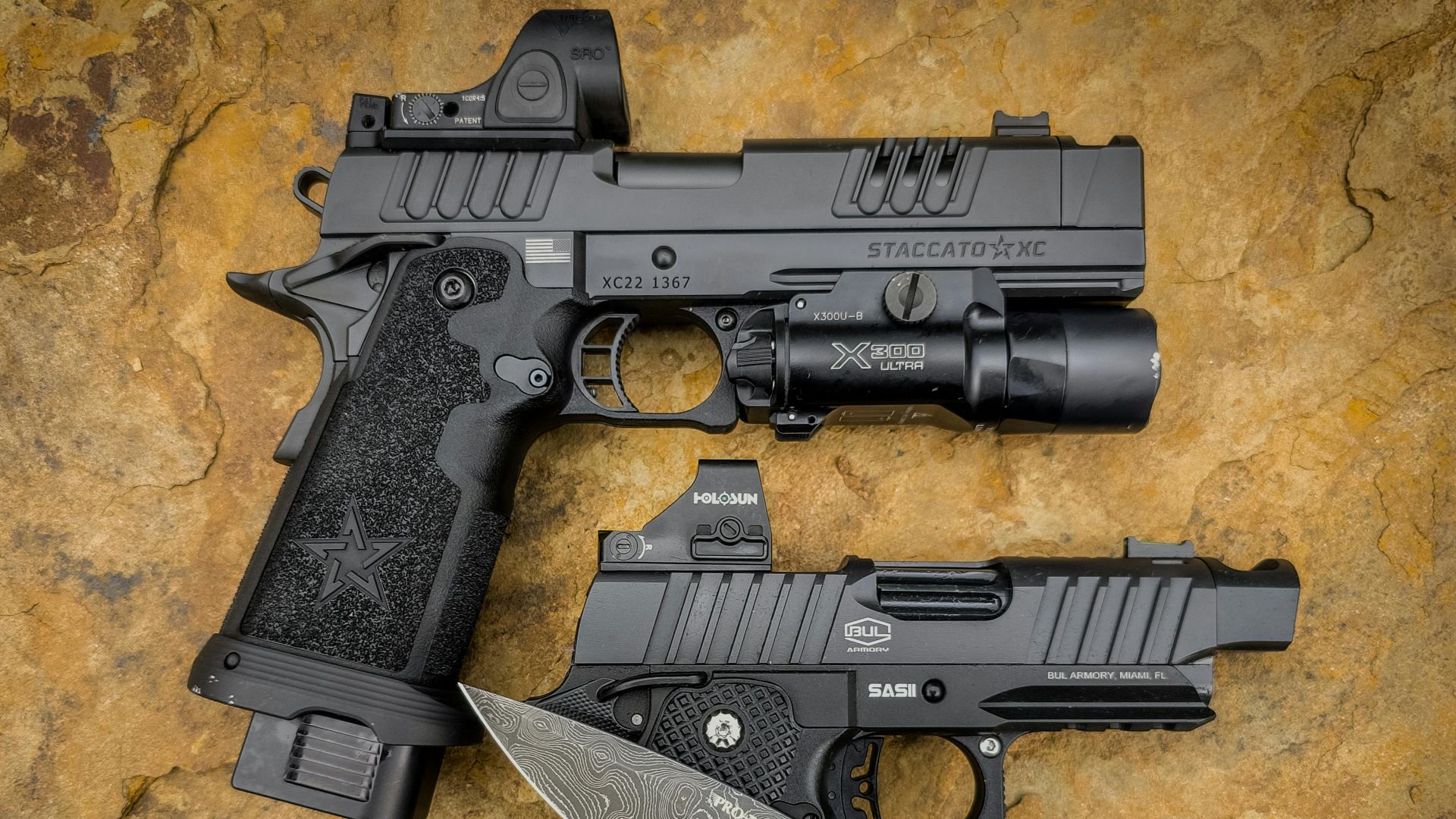 A detailed view of handguns and a tactical knife on a stone surface, showcasing precision details.
