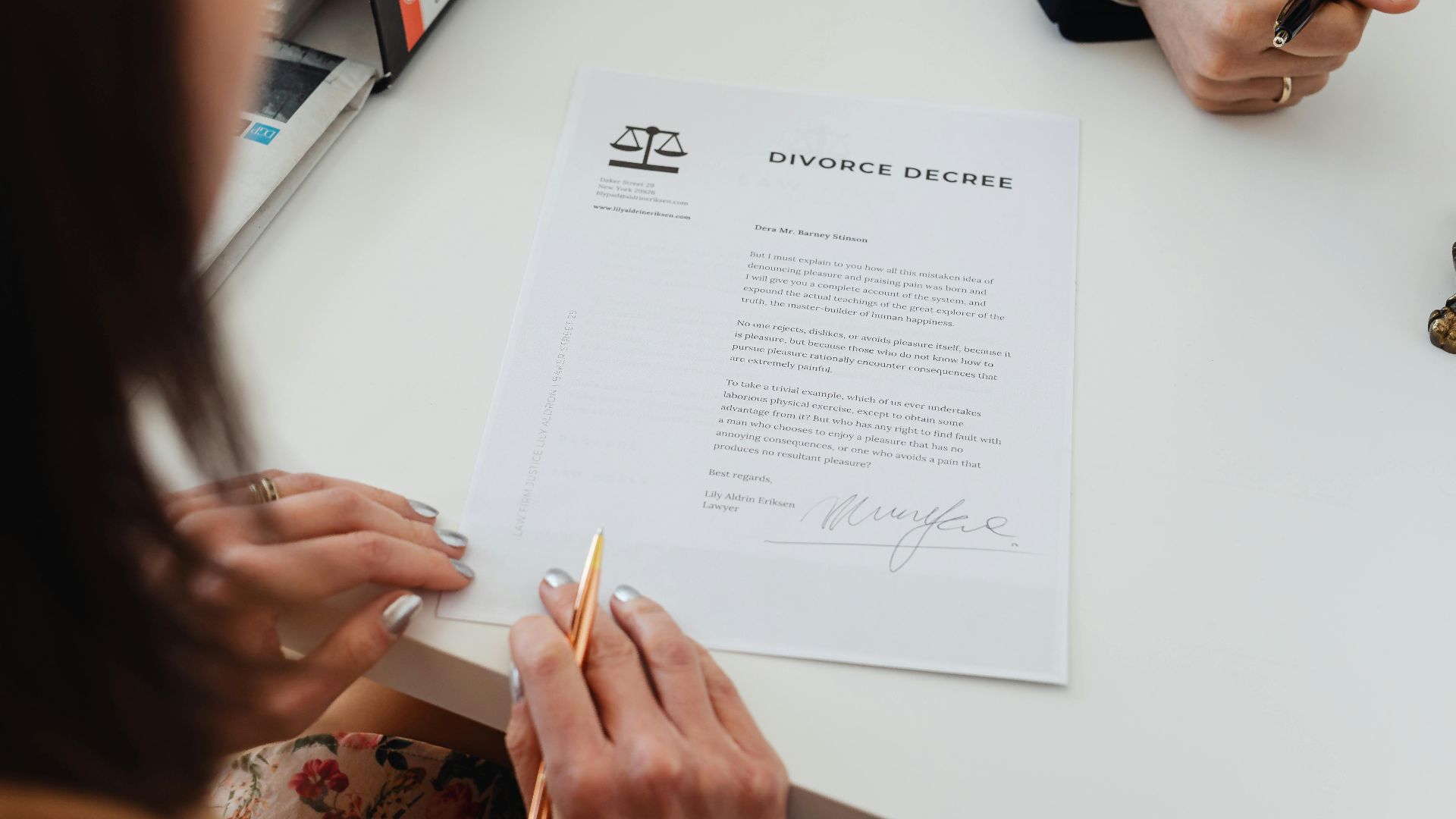 A close-up shot of two people signing a divorce decree at a law office table.