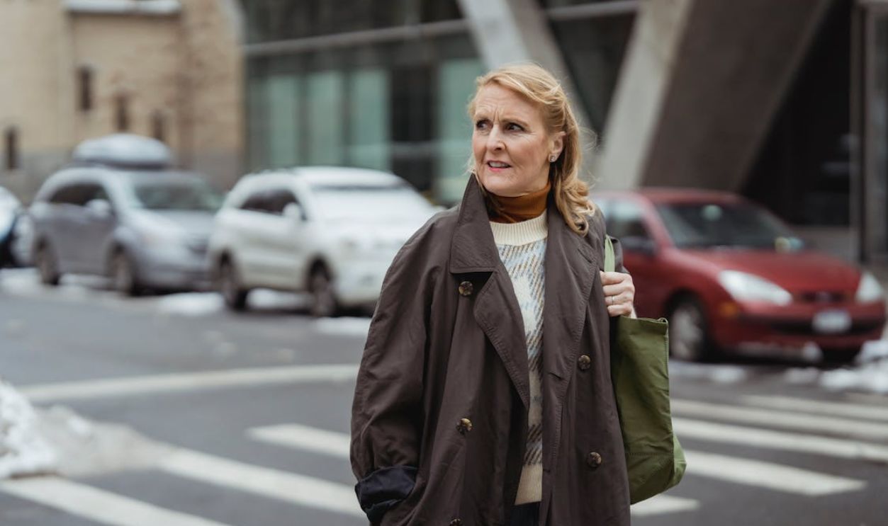 Contemplative mature woman on road in town