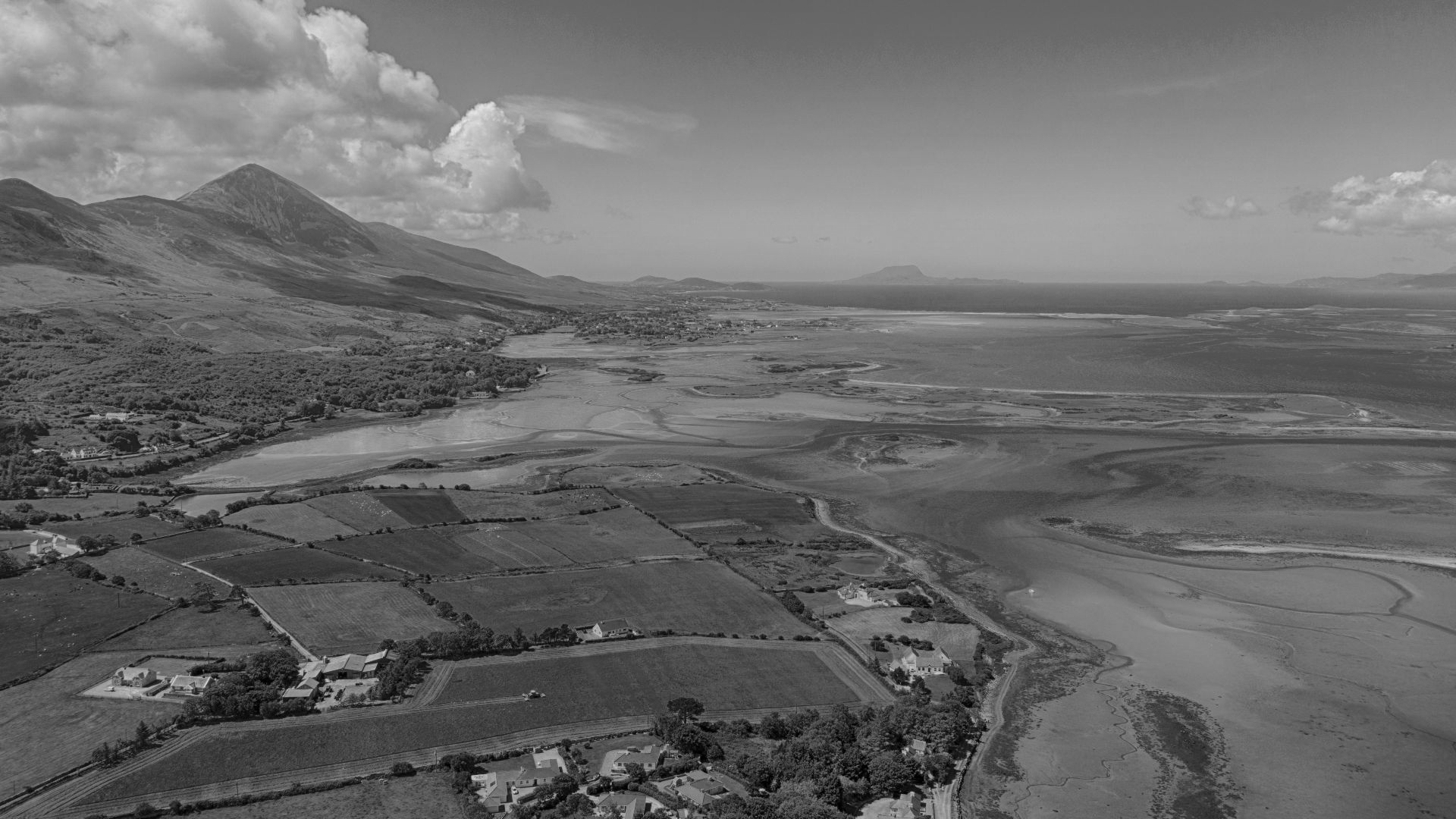 A view of Clew Bay from Westport bay.  Farming as well as evidence of Mariculture  can be seen from this aerial perspective.  There are several drowned drumlins in the bayas well as the tombolo beach 'Bertra' which can be seen in the distance.