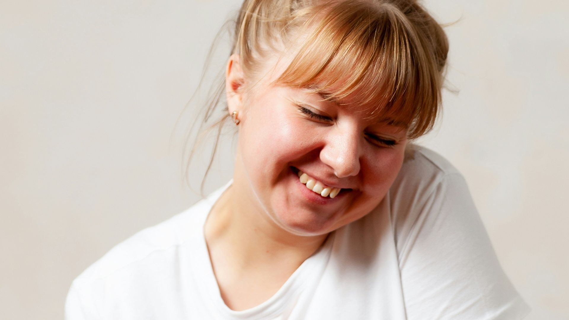 a person smiling with the eyes closed