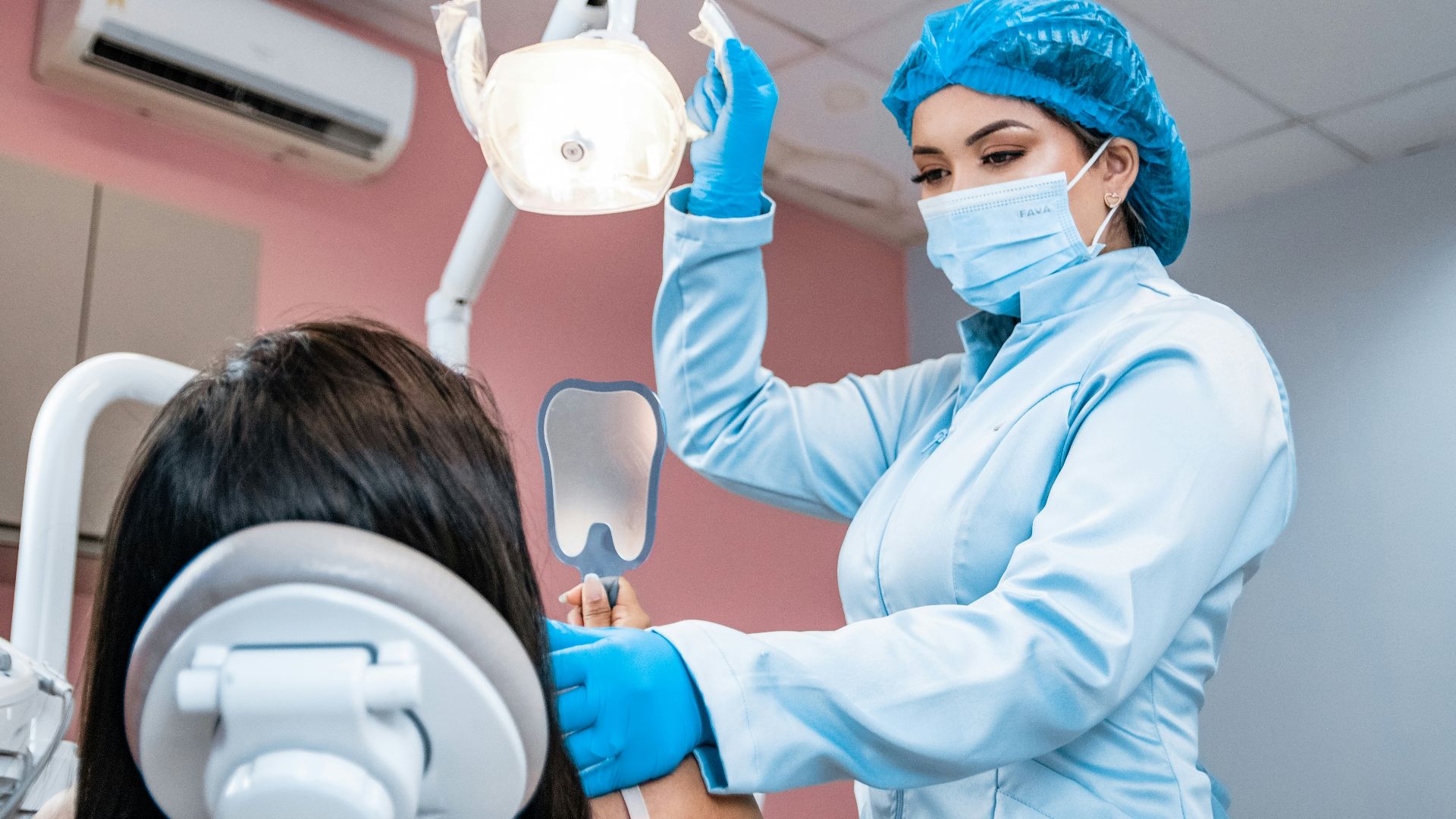 a woman getting her teeth checked by a dentist