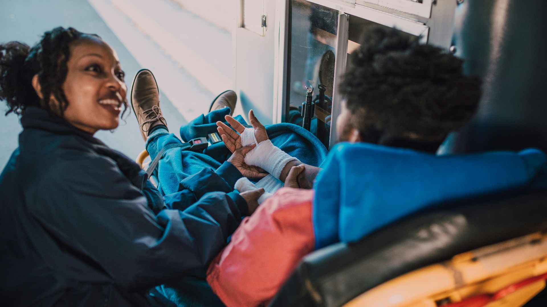 Paramedic attending to an injured patient inside an ambulance, showcasing empathy and support.