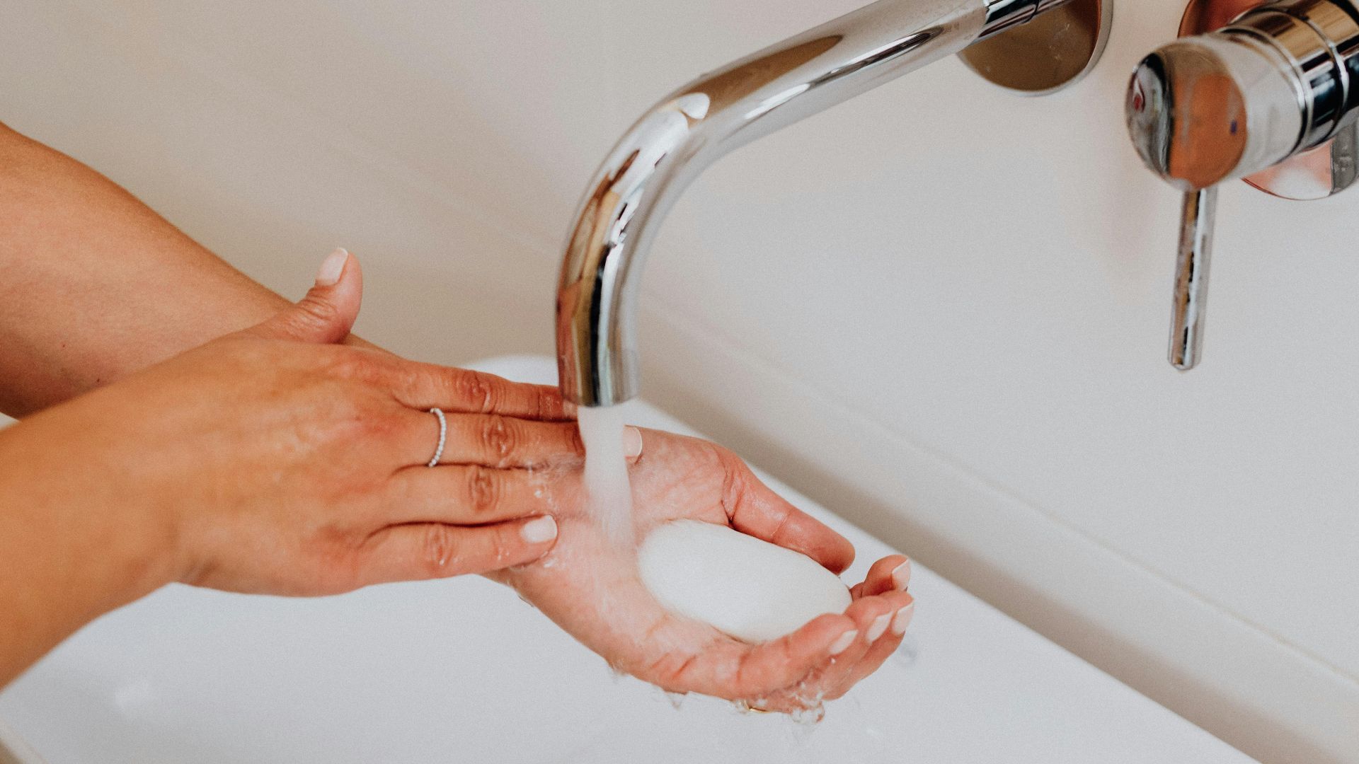 Clean hands with soap under running water promoting hygiene.