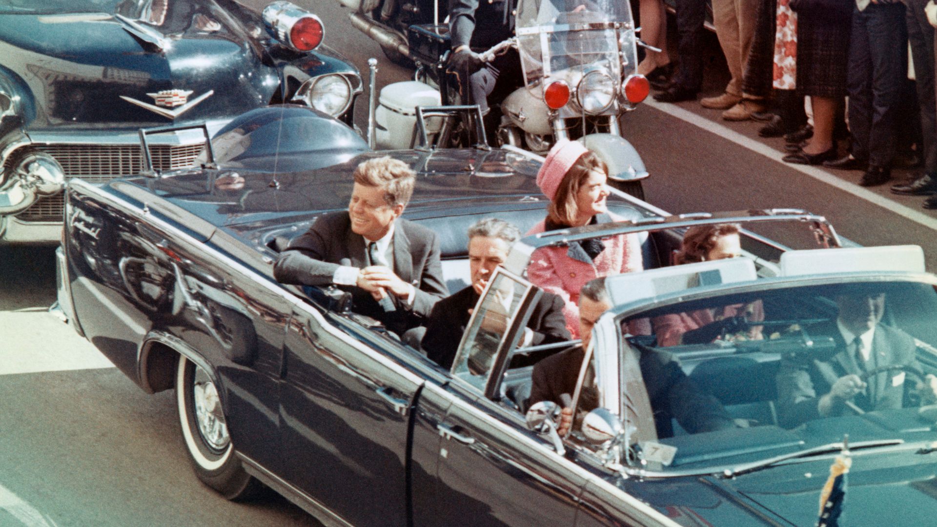Picture of President Kennedy in the limousine in Dallas, Texas, on Main Street, minutes before the assassination.  Also in the presidential limousine are Jackie Kennedy, Texas Governor John Connally, and his wife, Nellie.